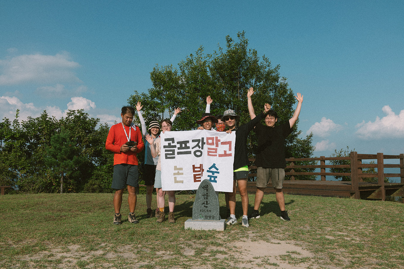 ‘백암산, 621.4m, 함양군’이라고 적힌 표지석이 있는 공터에서 7명의 사람들이 ‘골프장 말고 논 밭 숲’이라고 적힌 배너를 들고 서 있다.